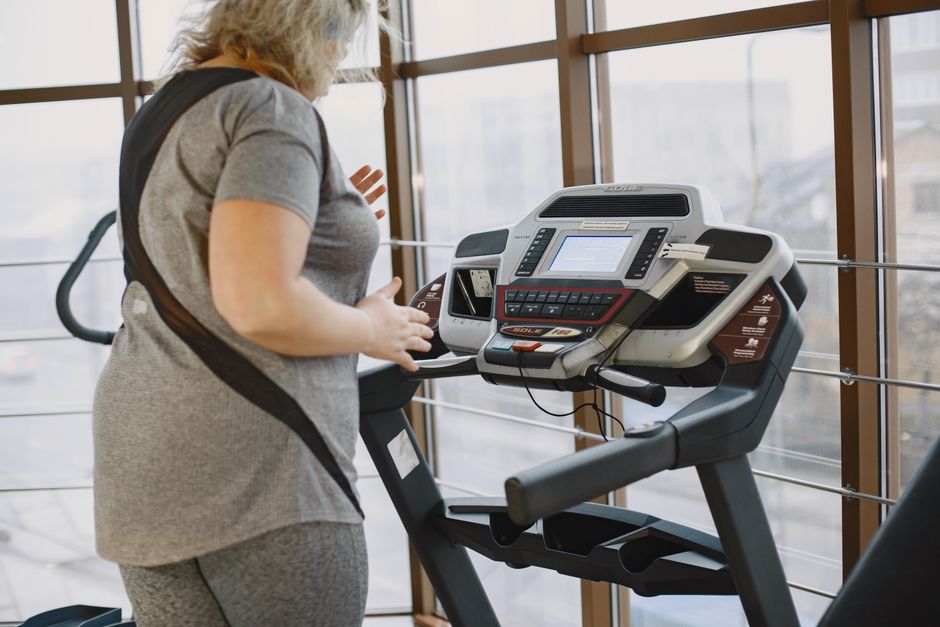 Woman exercising on treadmill in gym promoting healthy lifestyle and fitness.